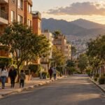 Calle residencial de edificios de ladrillo al atardecer en el suroccidente de Bogotá, con vecinos caminando